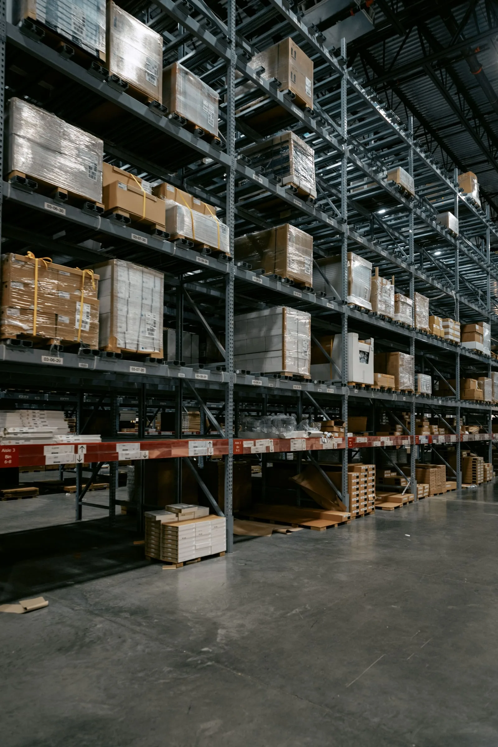 Pallet racking and stored goods beside a clear warehouse aisle